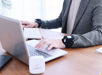 Office worker typing with SOLIGHT worn on both wrists